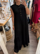 Women's checkered sleeveless jumpsuit with buttons and wide legs.