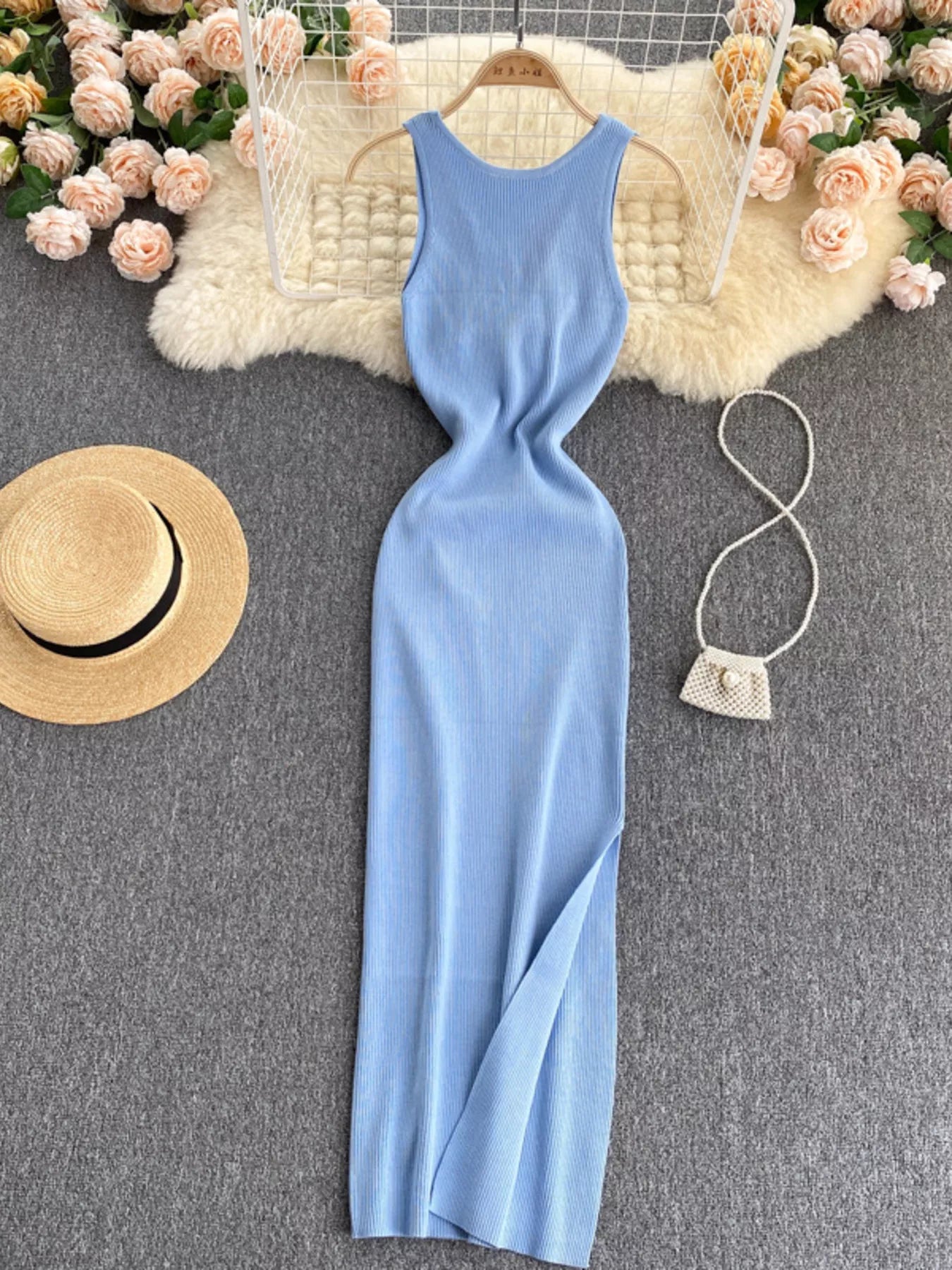 Light blue sleeveless knit bodycon midi dress, front view with side slit on hanger