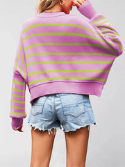 Back view of the purple sweater with green stripes, crew neck, and dropped shoulders worn with denim shorts.