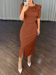 Mirror selfie full front view of a light brown ruched bodycon midi dress with a rose applique