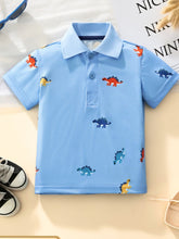 Front view of a sky blue children's polo shirt with small colorful dinosaur prints and buttons