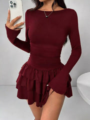 Burgundy layered ruffle long sleeve mini dress worn front facing in a mirror selfie holding a phone