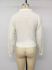 Back view of white cable knit long sleeve sweater on mannequin with ribbed hem