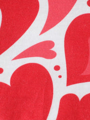 Close view of large red hearts and dots printed on white fabric of children's polo shirt