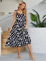 Women's black and white two-tone midi dress with a low back and V-neck.