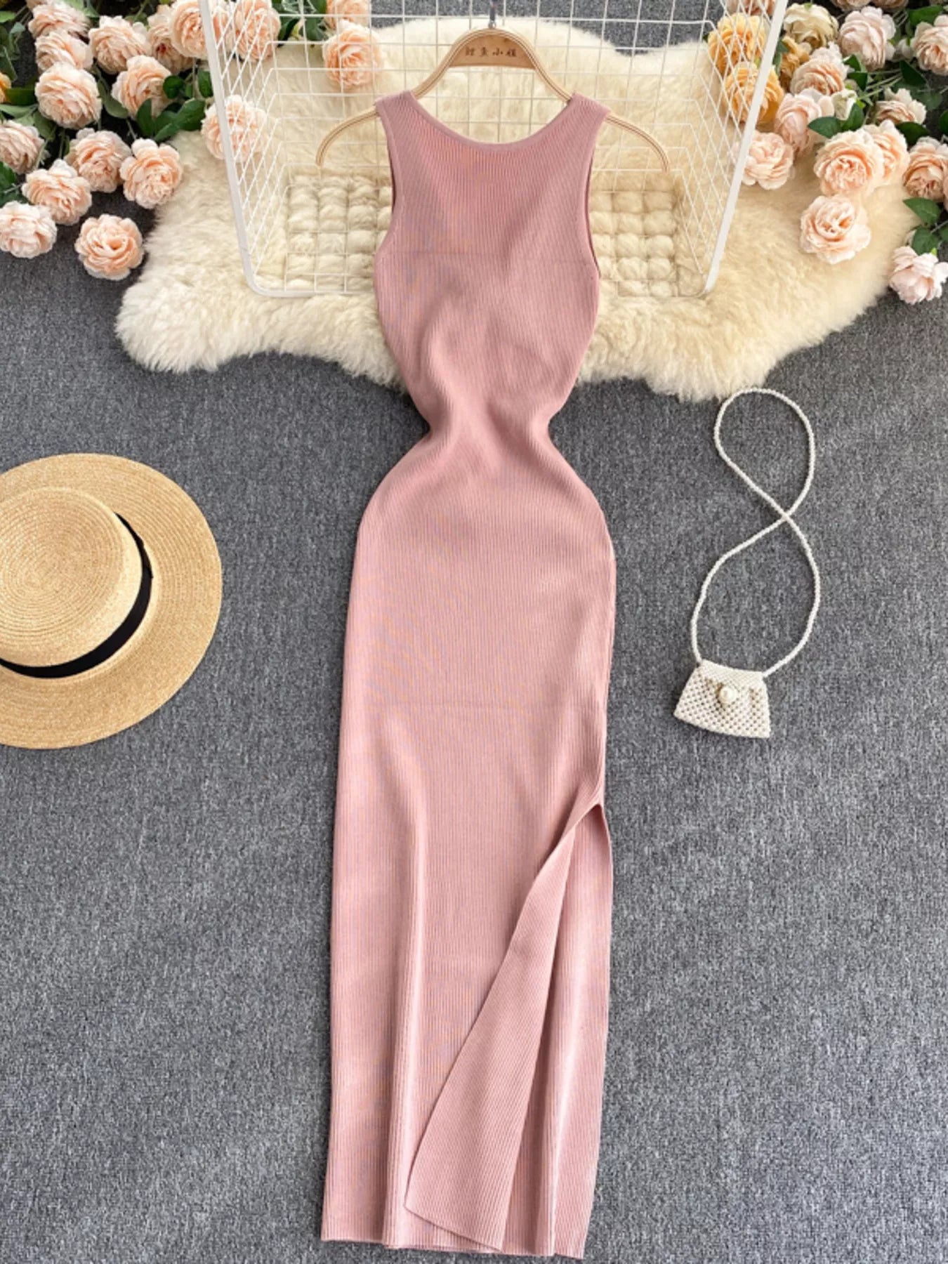 Pink sleeveless knit bodycon midi dress, front view with side slit on hanger