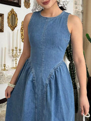 Dark blue sleeveless denim midi dress, close front view of round neckline and bodice seaming