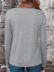 Back view of a gray long-sleeve V-neck T-shirt worn with blue jeans