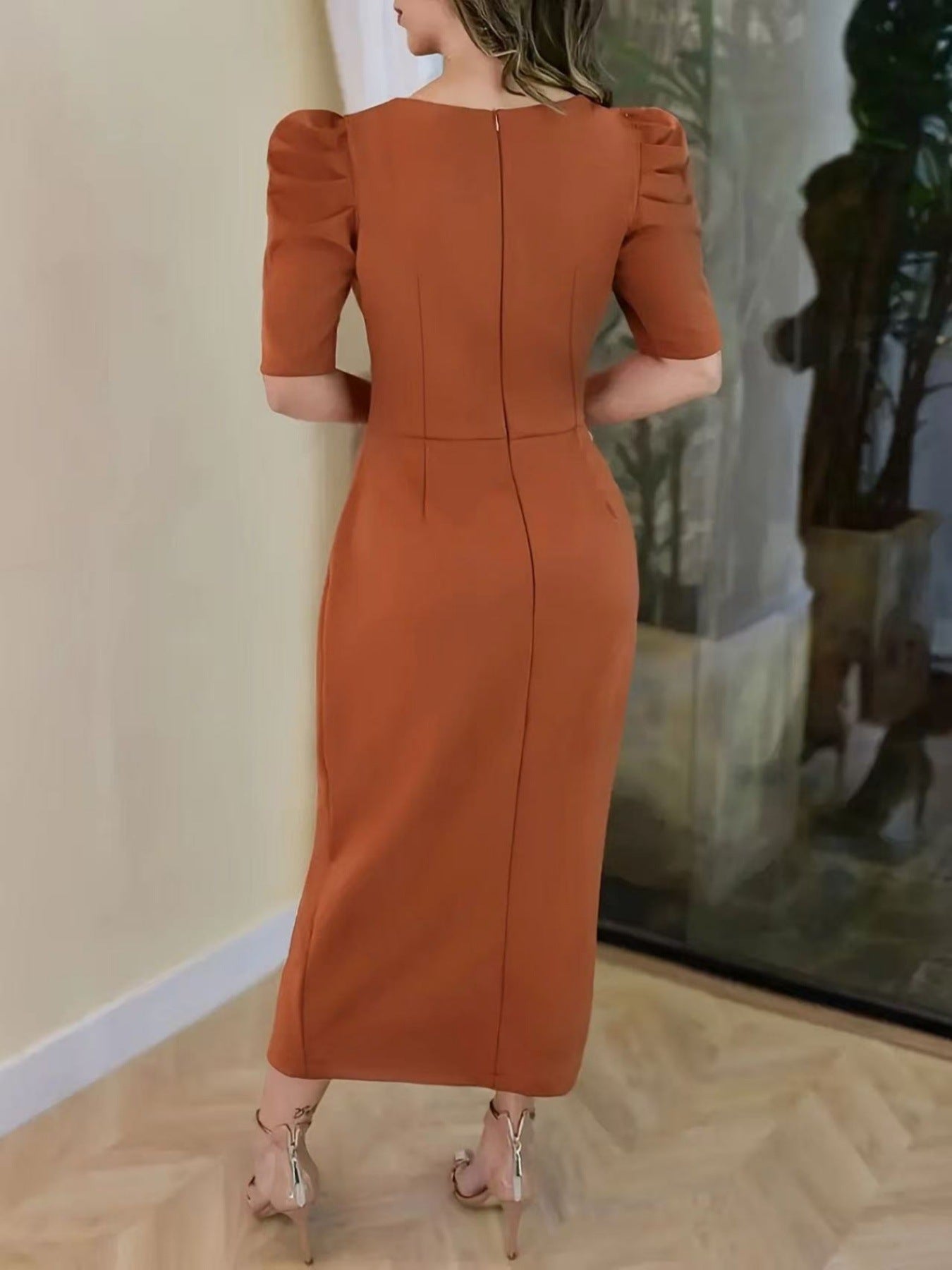 Back view of a light brown ruched bodycon midi dress showing the back zip and puff sleeves