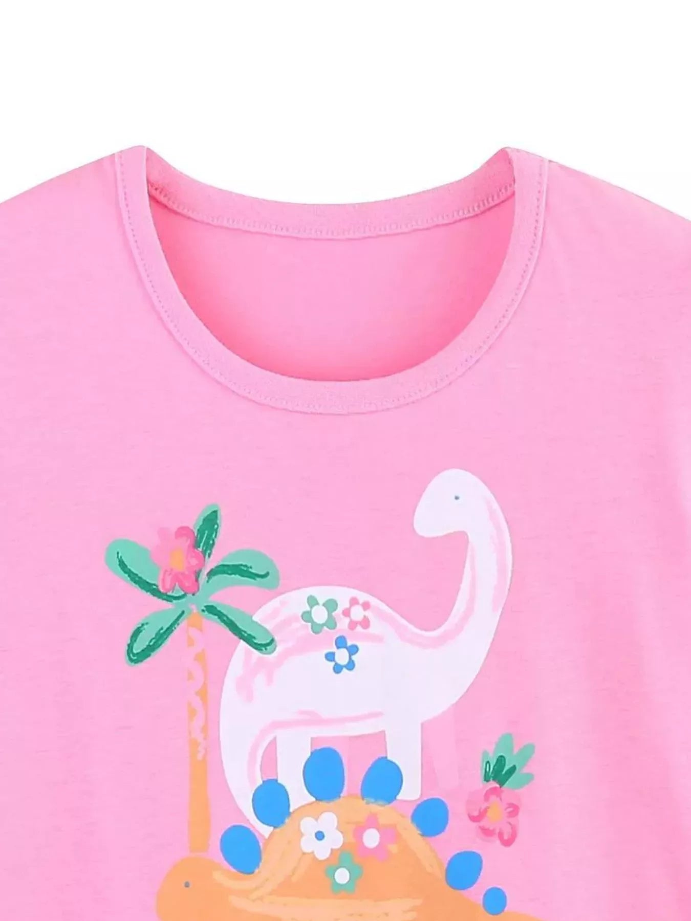 Close-up of the pink children's t-shirt neckline above a white dinosaur graphic