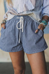 Women's dusty blue striped denim shorts with a drawstring waist and pockets.