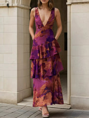 Front view of a deep purple floral V neck maxi dress with ruffled layers standing outdoors