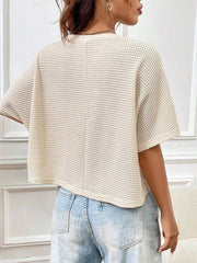 Back view of a cream waffle-knit cropped T-shirt with short sleeves and relaxed fit