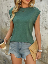 Women's green round neck cap sleeve T-shirt styled with denim shorts and accessories