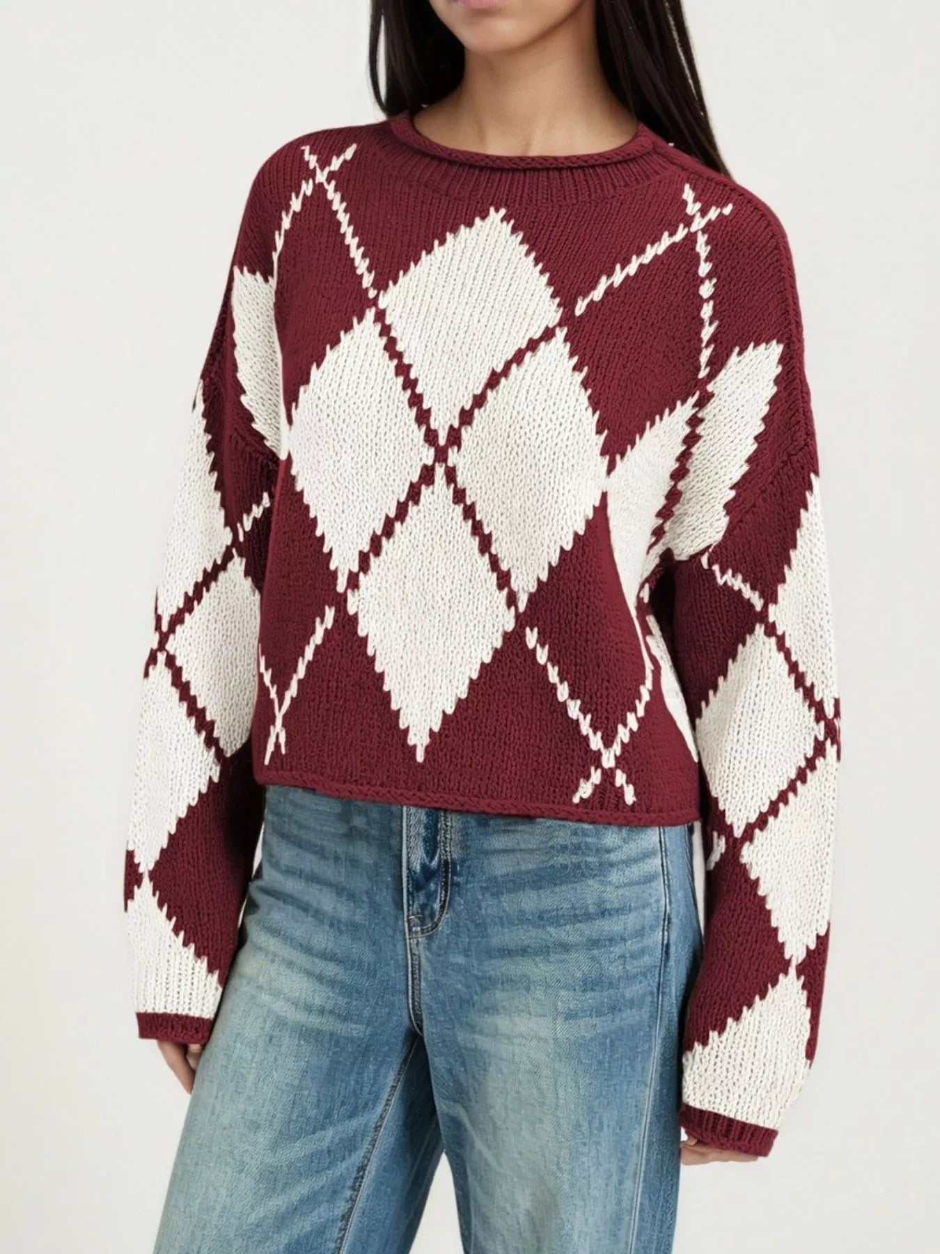 On-model front view of a burgundy and cream argyle knit sweater with dropped shoulders