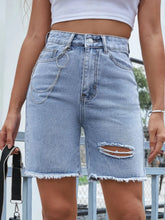 Women's distressed denim shorts with buttons and raw hems.