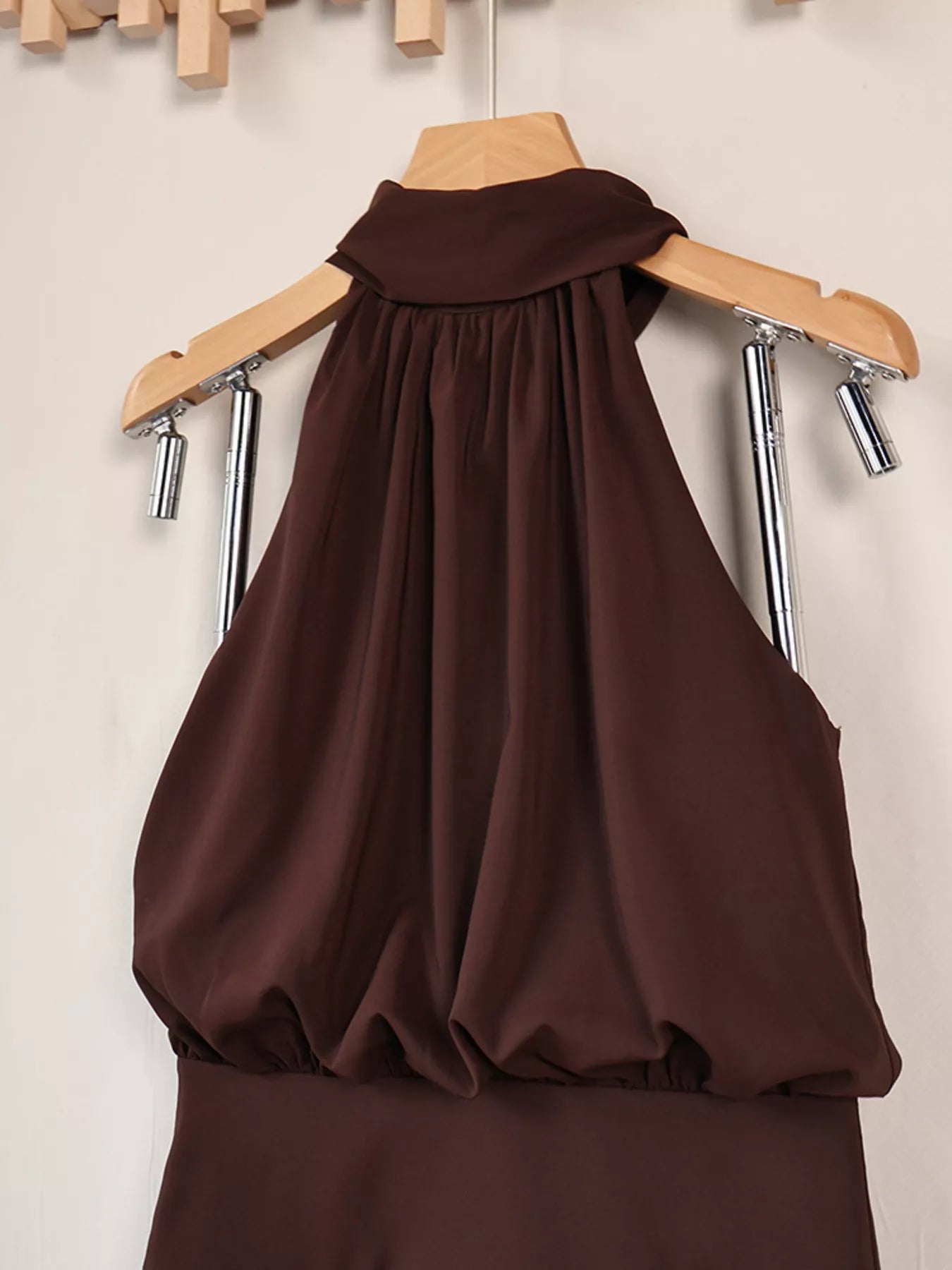 Brown halter mini dress on hanger, close view of gathered bodice and neckline