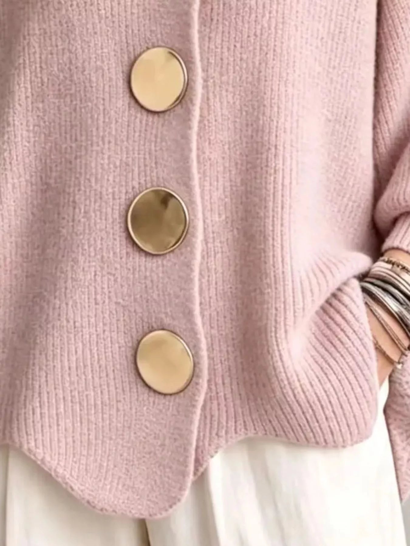 Close up of the pale pink cardigan gold buttons and scalloped hem