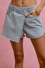 Women's washed denim skort with a wrap design and pockets.