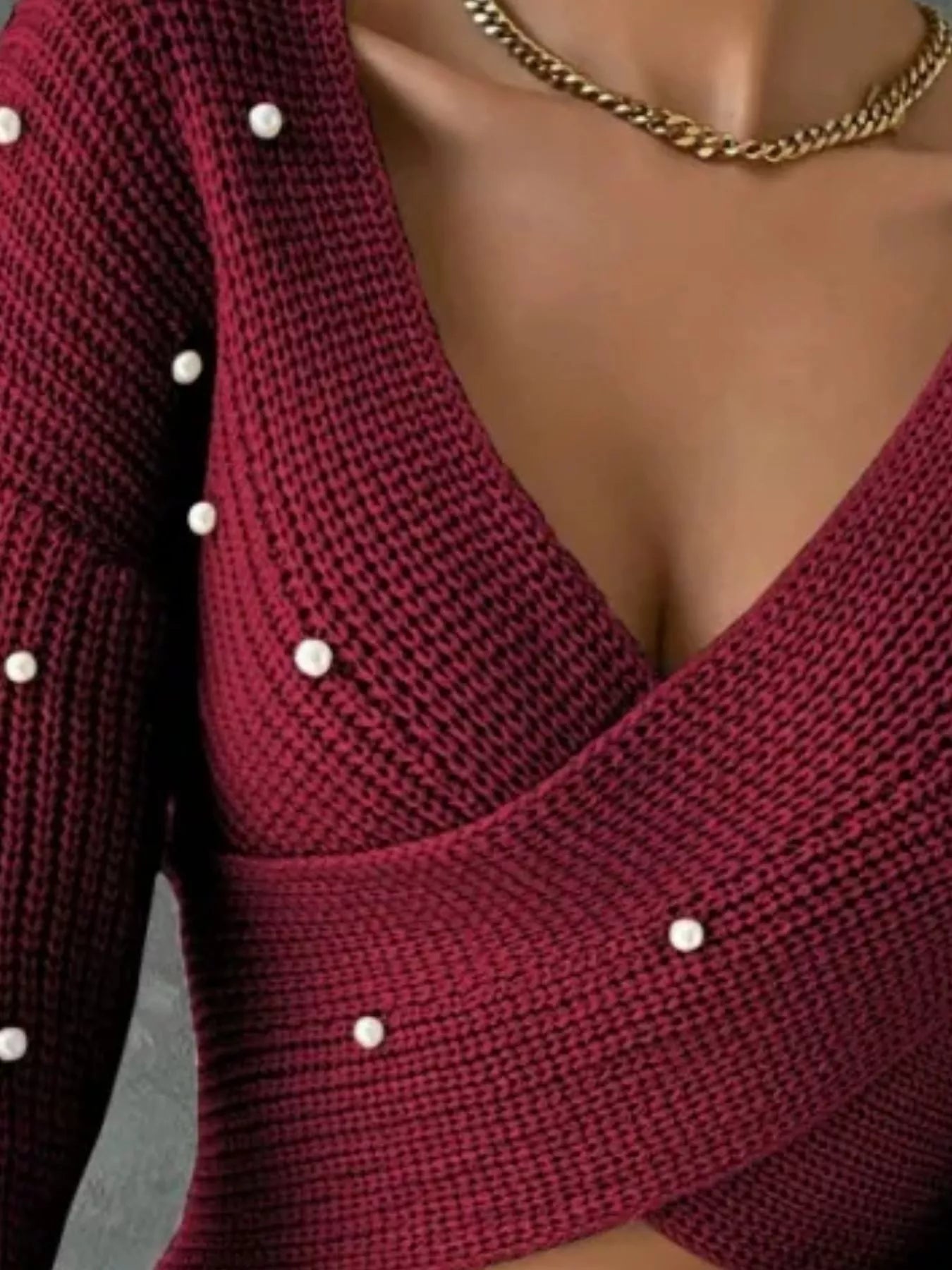 Close view of the burgundy crisscross sweater V neck and pearl details