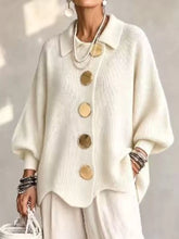 Front view of a cream knit cardigan with large gold buttons and lantern sleeves
