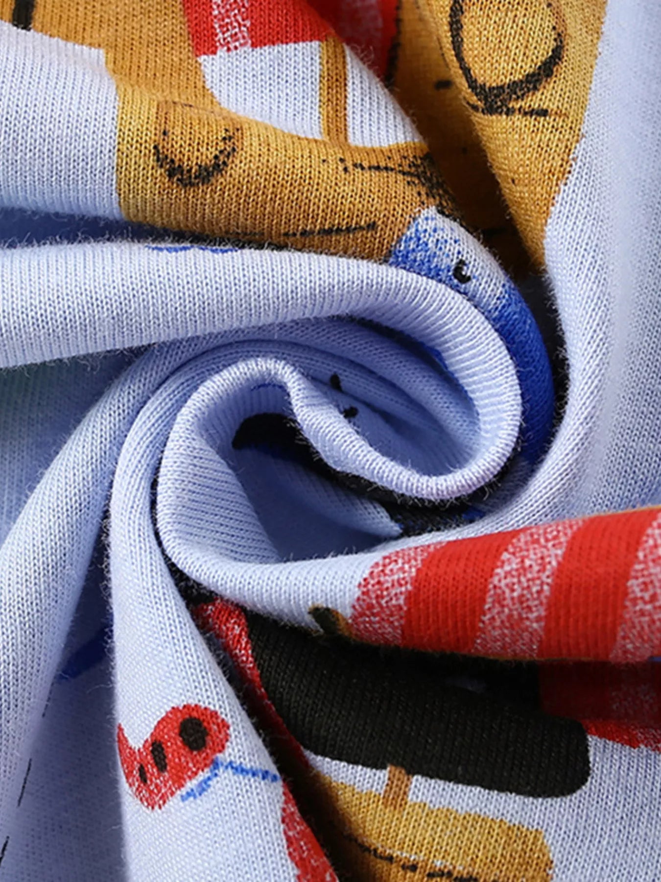 Close-up of the twisted light blue fabric showing the colorful pirate print texture