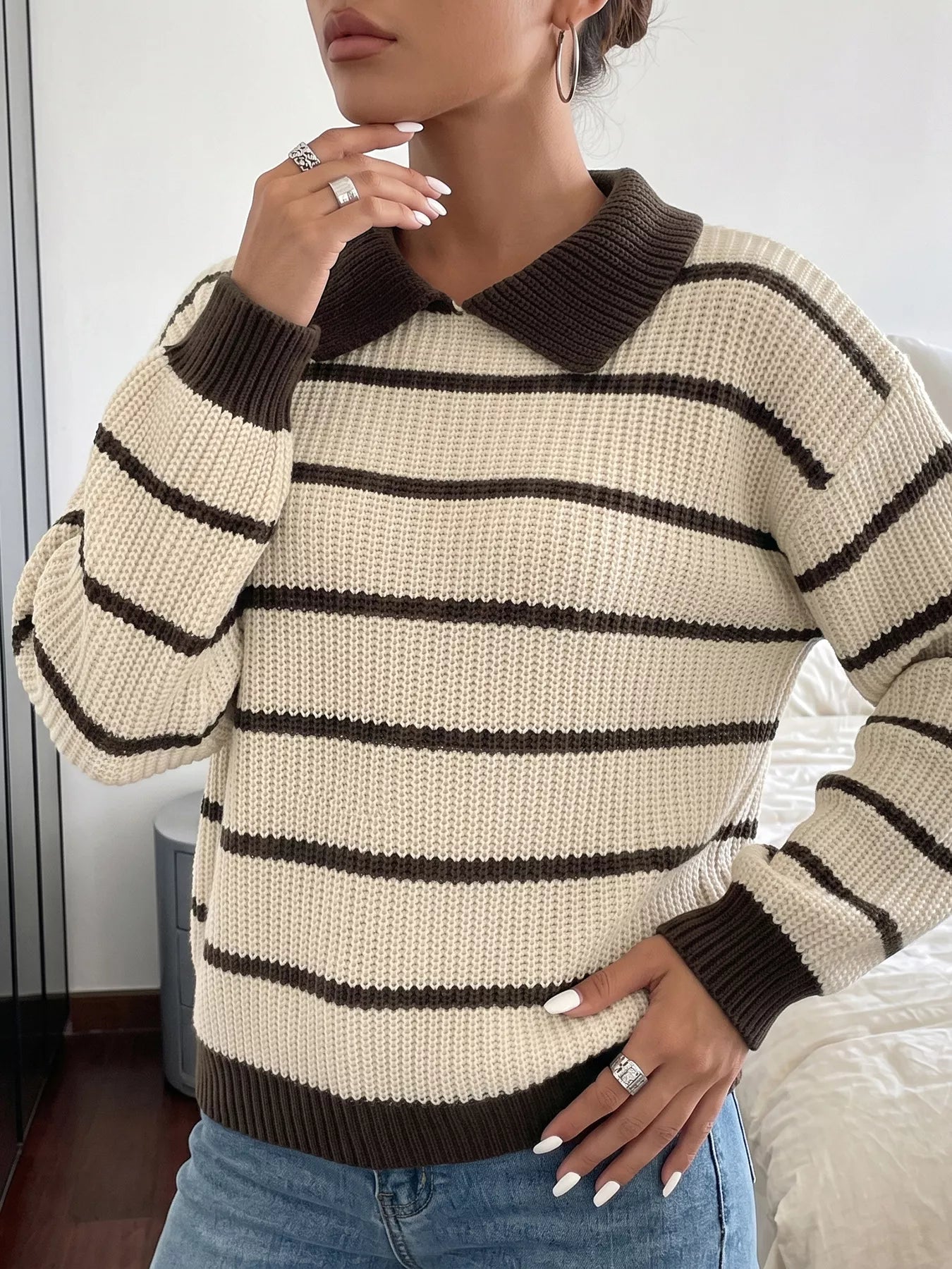 Front view of a cream and brown striped knit polo sweater with brown collar.