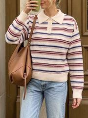 Front view of a cream striped polo sweater with a button placket, holding a drink