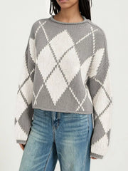 On-model front view of a gray and cream argyle knit sweater with dropped shoulders