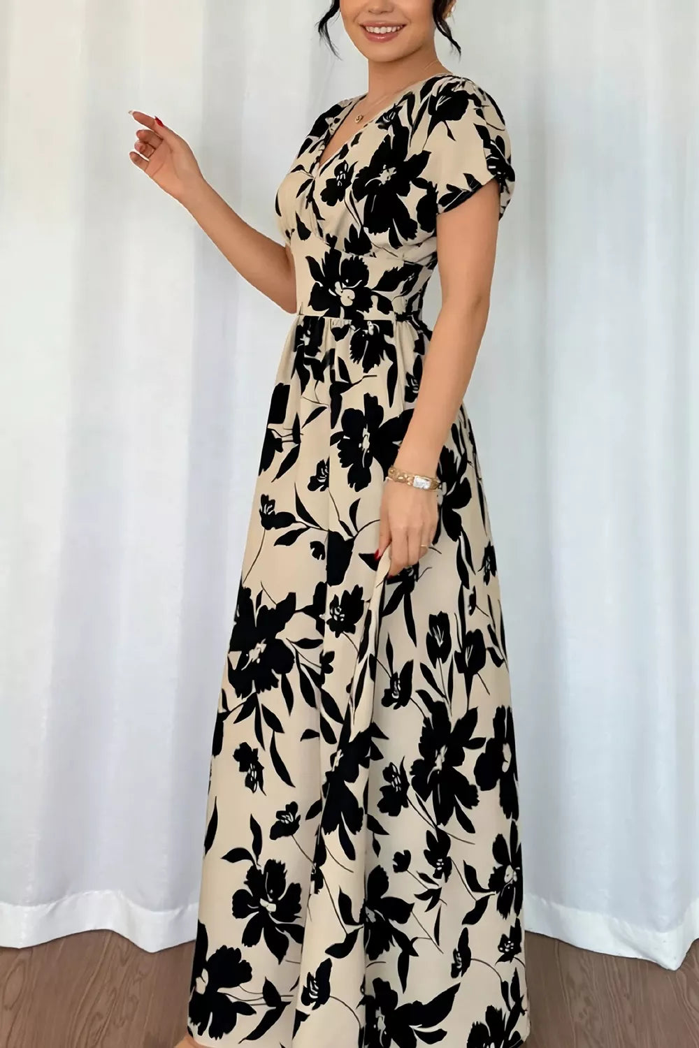 Three quarter view of khaki floral short sleeve maxi dress with V neckline and flared skirt