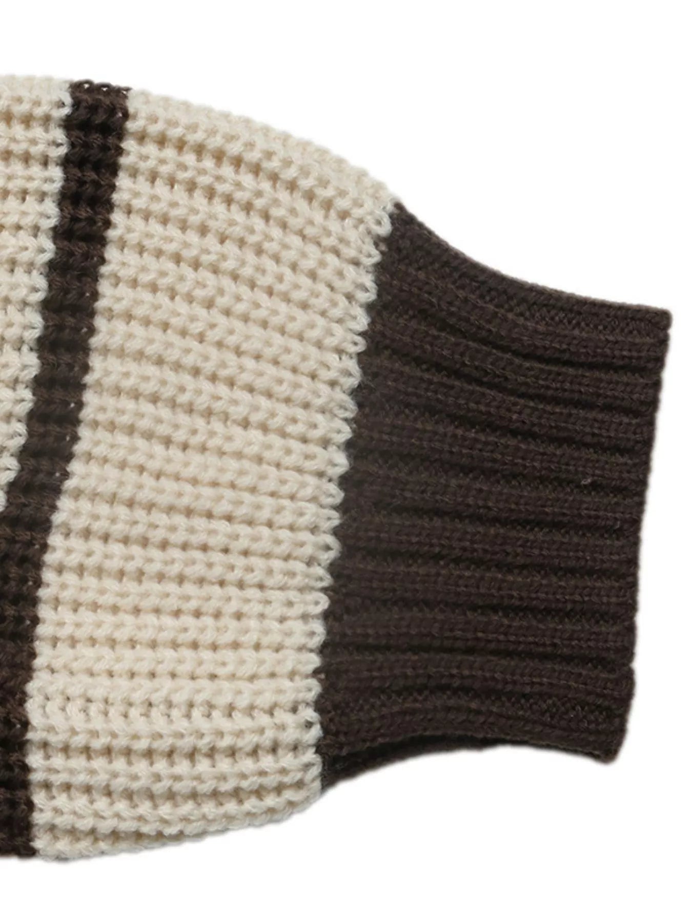 Close up of a brown ribbed cuff on a cream and brown striped knit sweater.