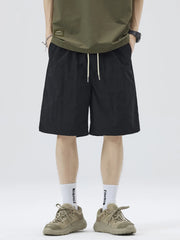 Men's black loose-fit shorts with stripe detail, a drawstring waist and pockets.