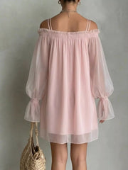 Back view of a dusty pink off shoulder mini dress with sheer sleeves and smocked neckline