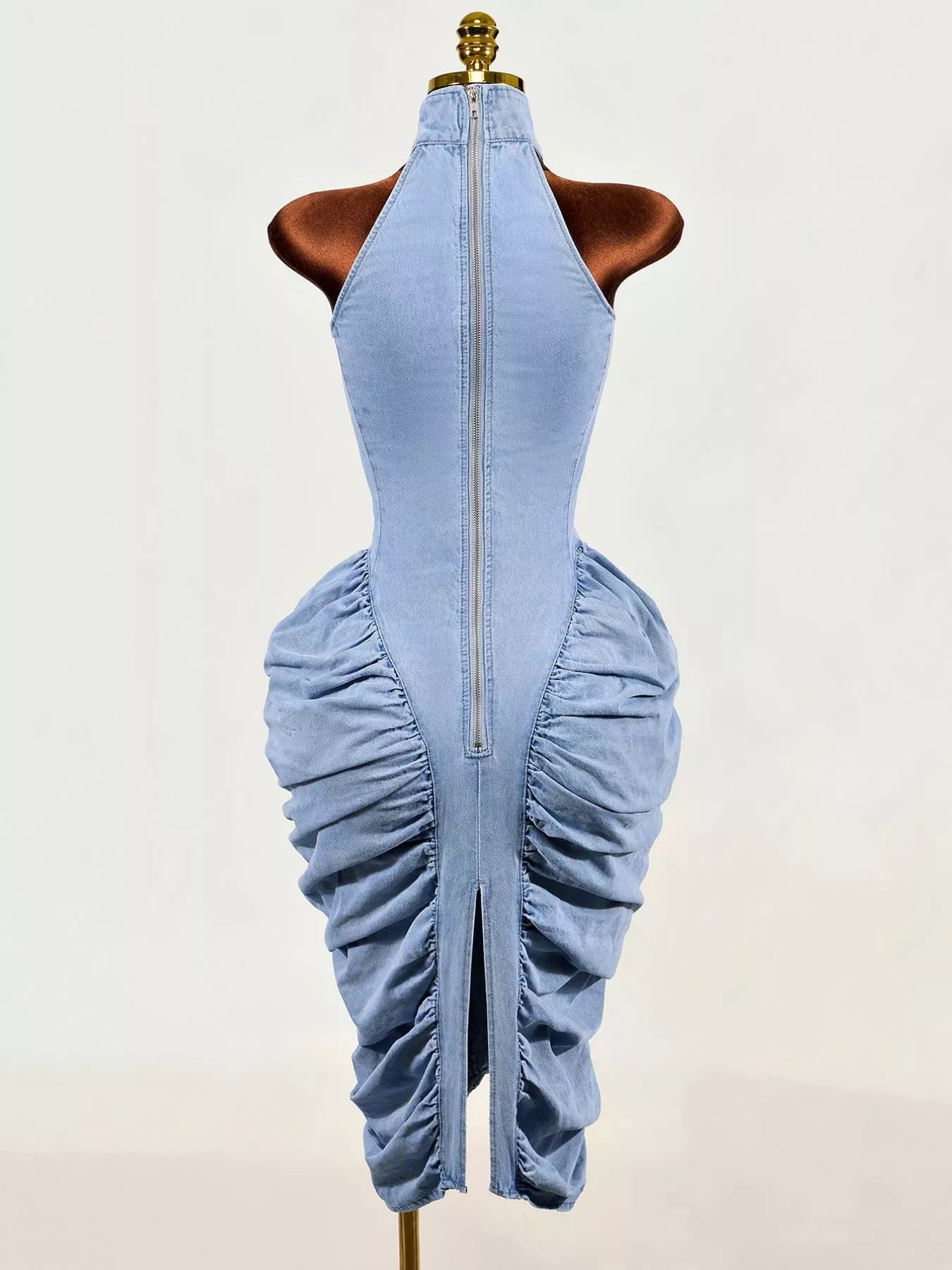 Light blue sleeveless mock neck ruched bodycon denim dress on mannequin, back view with zip