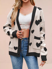 Cream knit cardigan with black hearts and black trim worn open