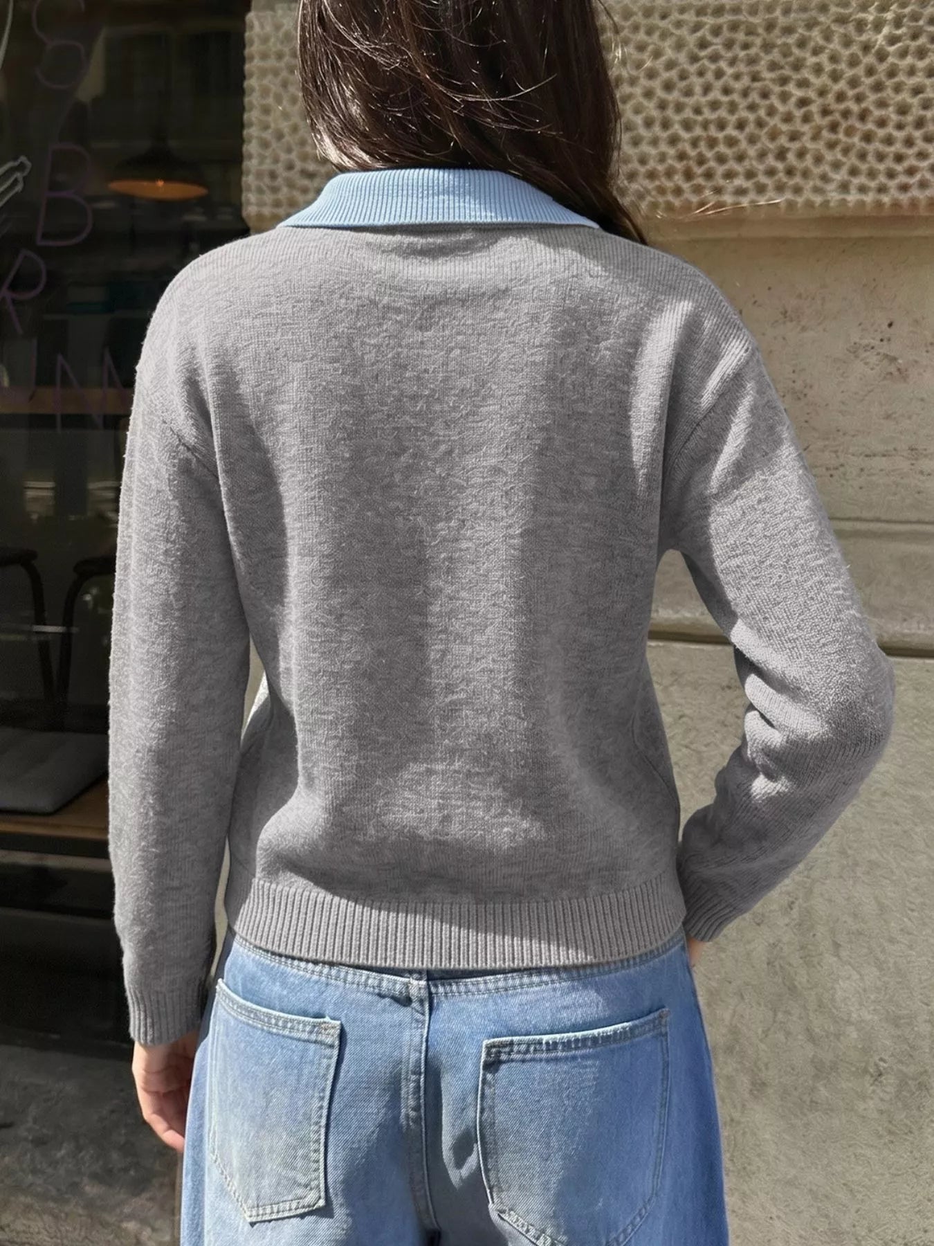 Back view of the gray knit sweater with a light blue collar and long sleeves