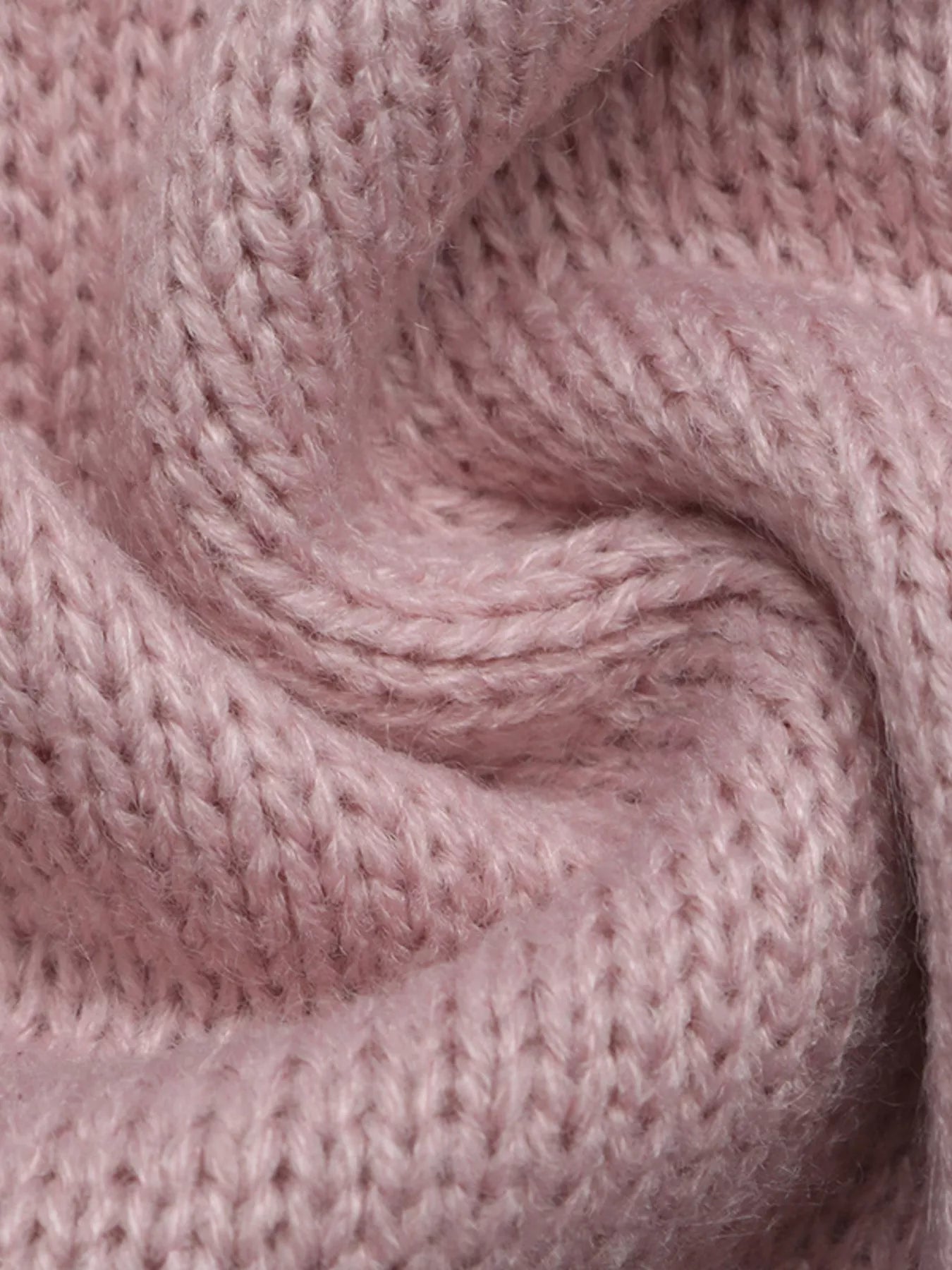 Close up showing the soft pink knit texture of the V neck sweater.