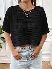 Black waffle-knit cropped T-shirt with short sleeves, shown styled with light-wash jeans.
