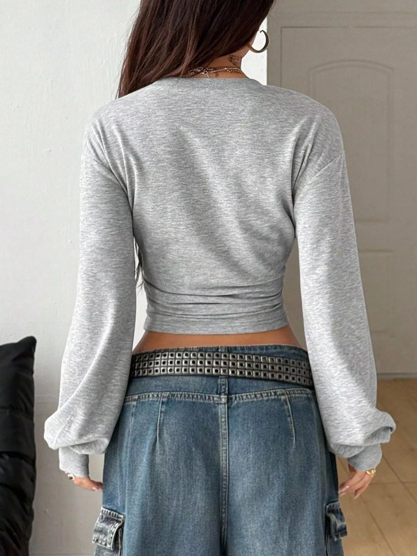 Back view of light gray long sleeve cropped t shirt with wide sleeves and jeans