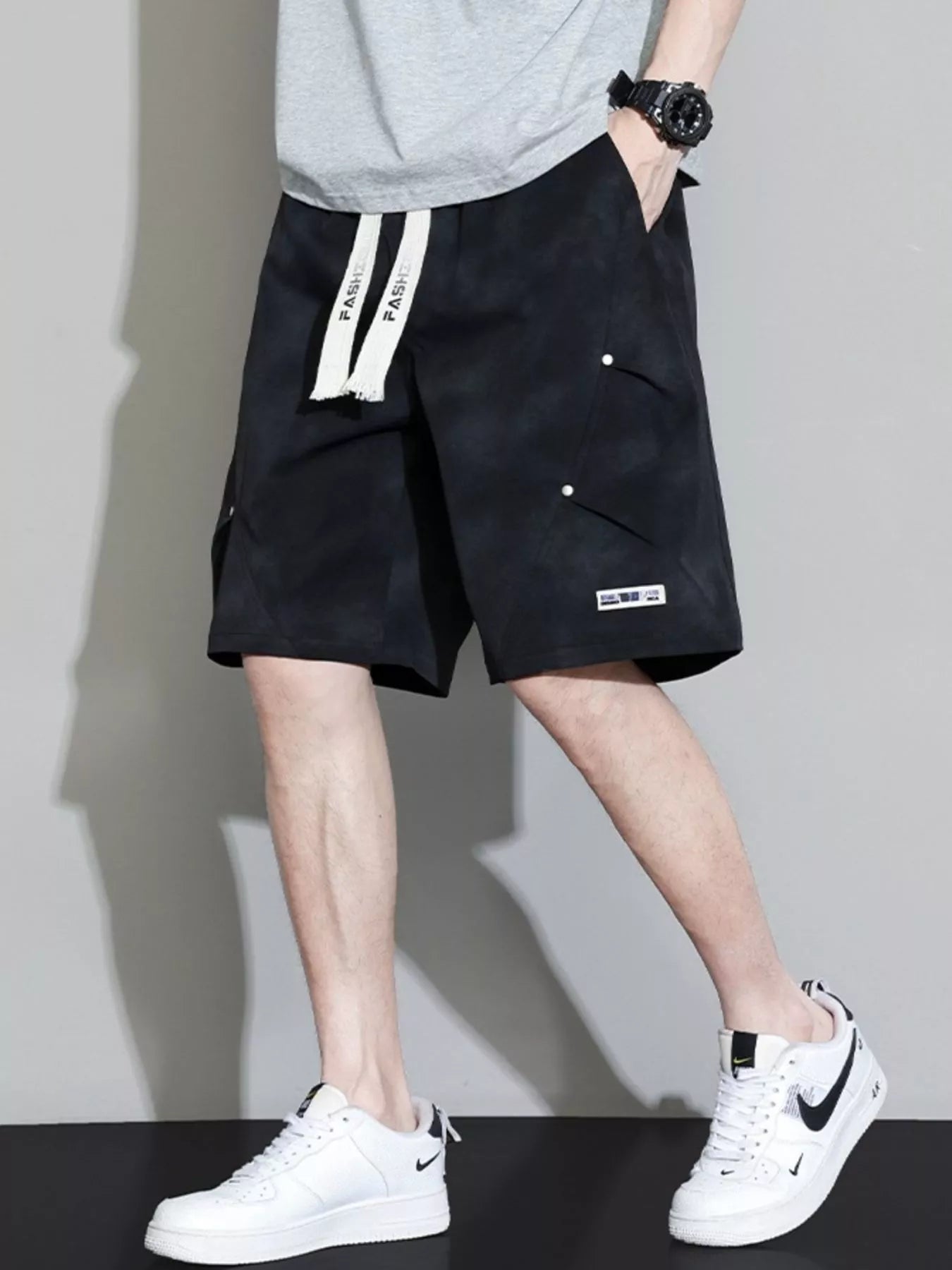 Men's black cargo shorts with a drawstring waist and pockets.