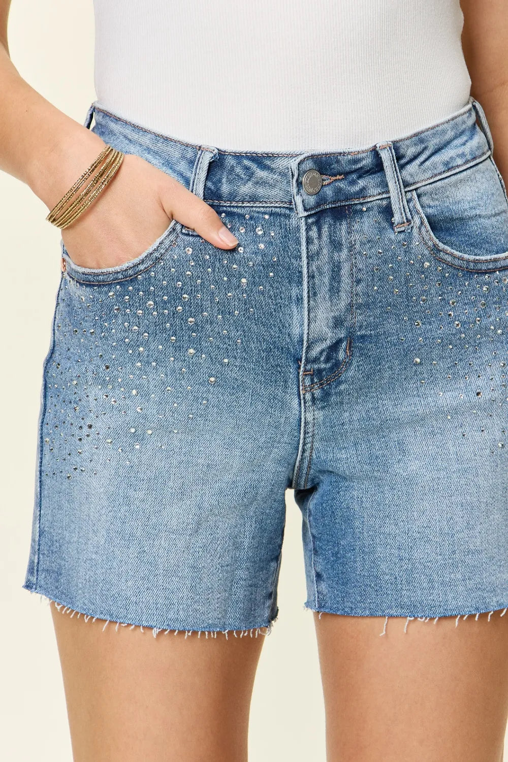 Women's high-waisted denim shorts with rhinestone embellishments and pockets.