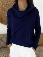 On-model front view of a navy cowl neck sweater with a draped asymmetric collar and long sleeves