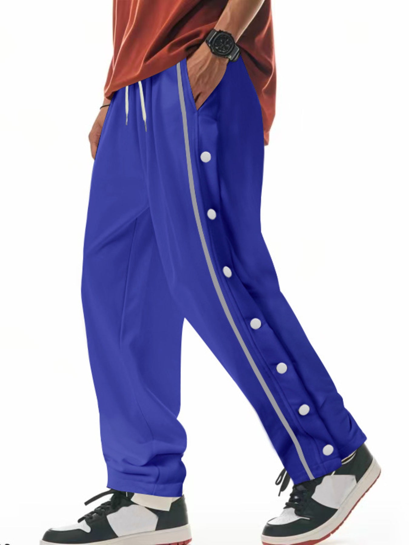 Men's royal blue loose-fit track pants with side snap buttons and pockets.