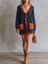 Front view of a dark navy knit cardigan with burnt orange trim and patch pockets