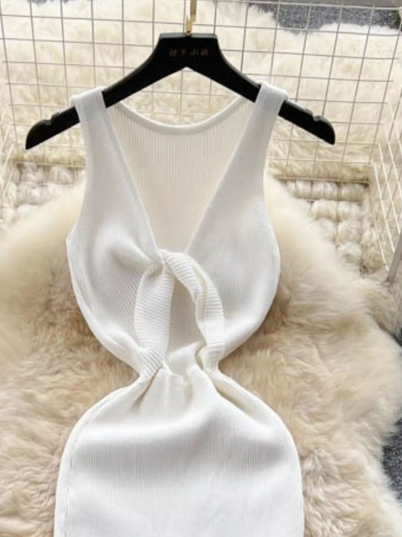 Close back view of white ribbed knit dress showing knotted open back detail