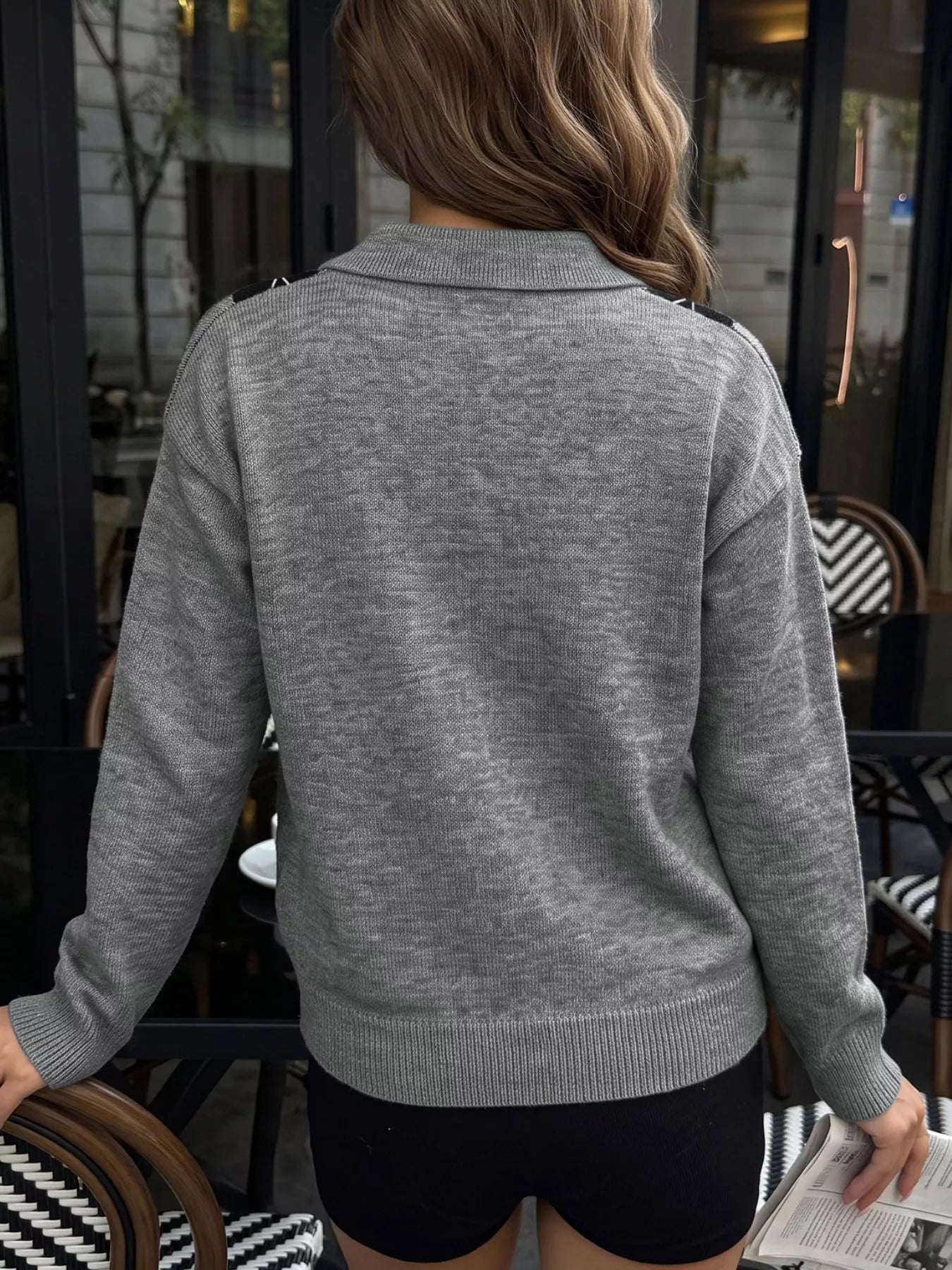 Back view of a plain gray long sleeve polo sweater with a ribbed hem