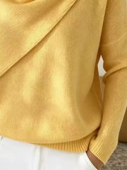 Close-up of the yellow sweater lower body and long sleeve showing the ribbed hem and knit texture