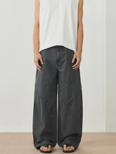 Men's dark gray wide-leg pants with an oversized fit and pockets.