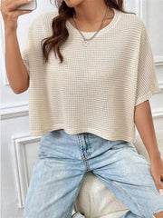 Cream waffle-knit cropped T-shirt with short sleeves, shown styled with light-wash jeans.