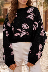 Black floral pattern pullover sweater with pink flowers and puff sleeves, front view on model outdoors